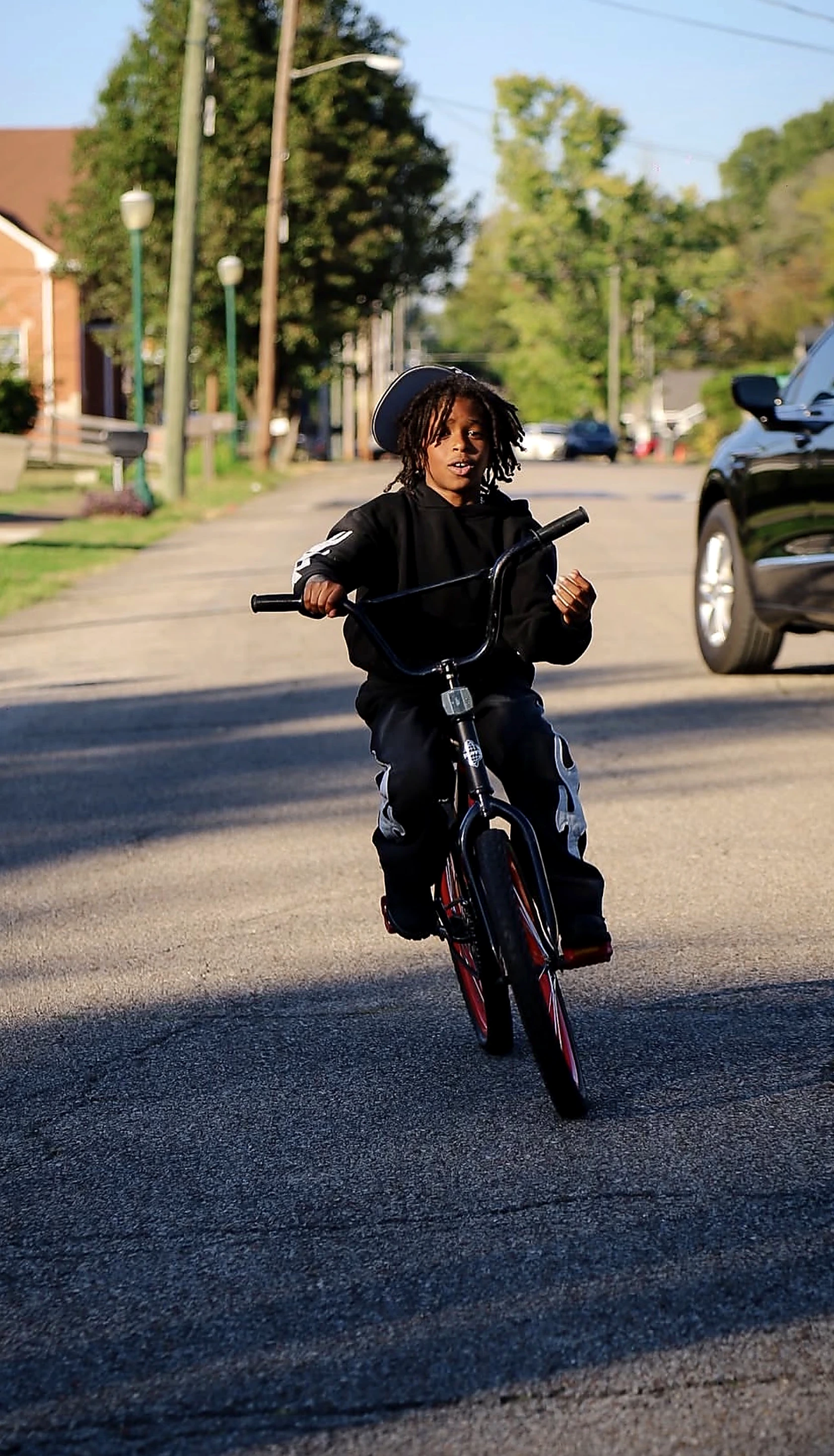 Big Mondo riding his bicycle down a neighborhood street